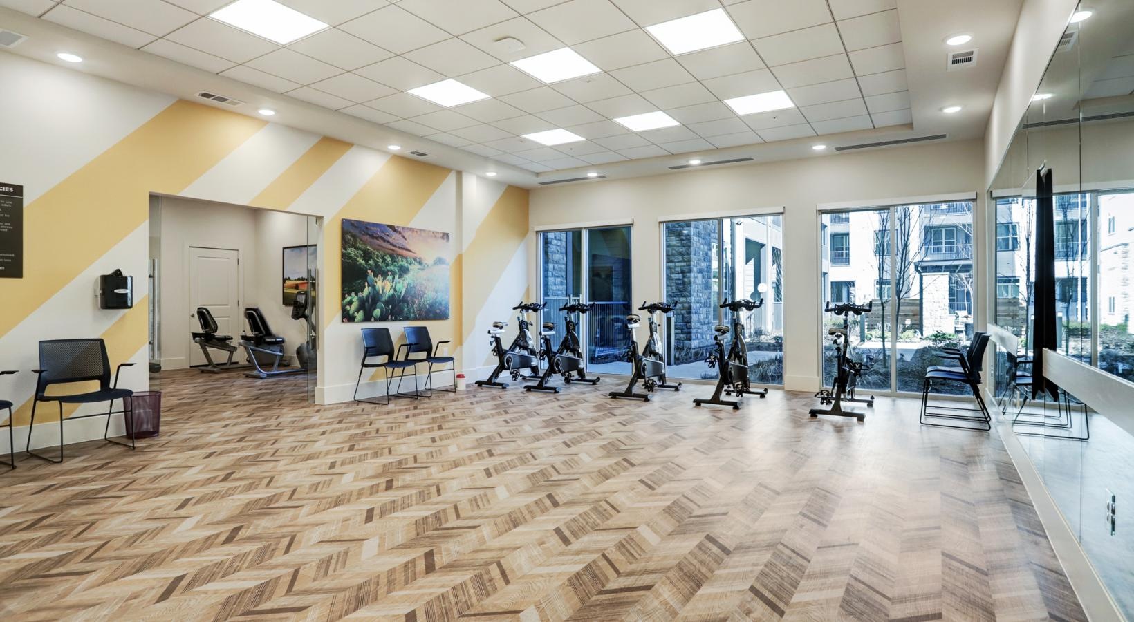 Access to resident-only features a large room with a large floor and stationary bikes
