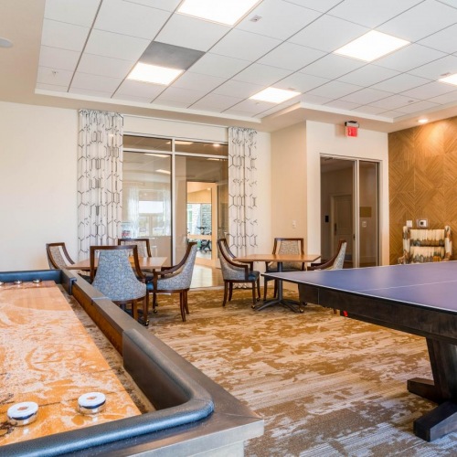 Access to resident-only features a room with a shuffle board and table and chairs