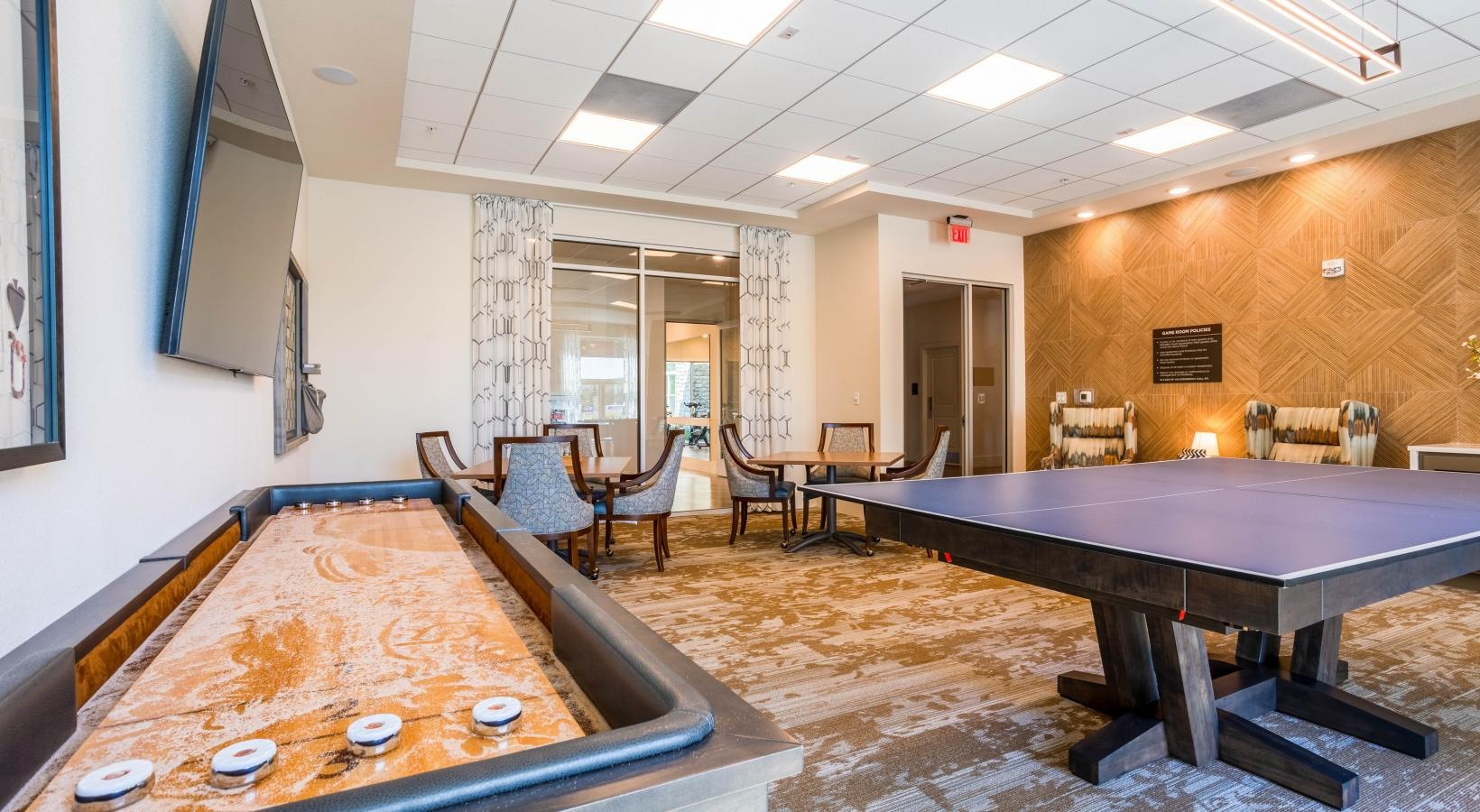 Access to resident-only features a room with a shuffle board and table and chairs