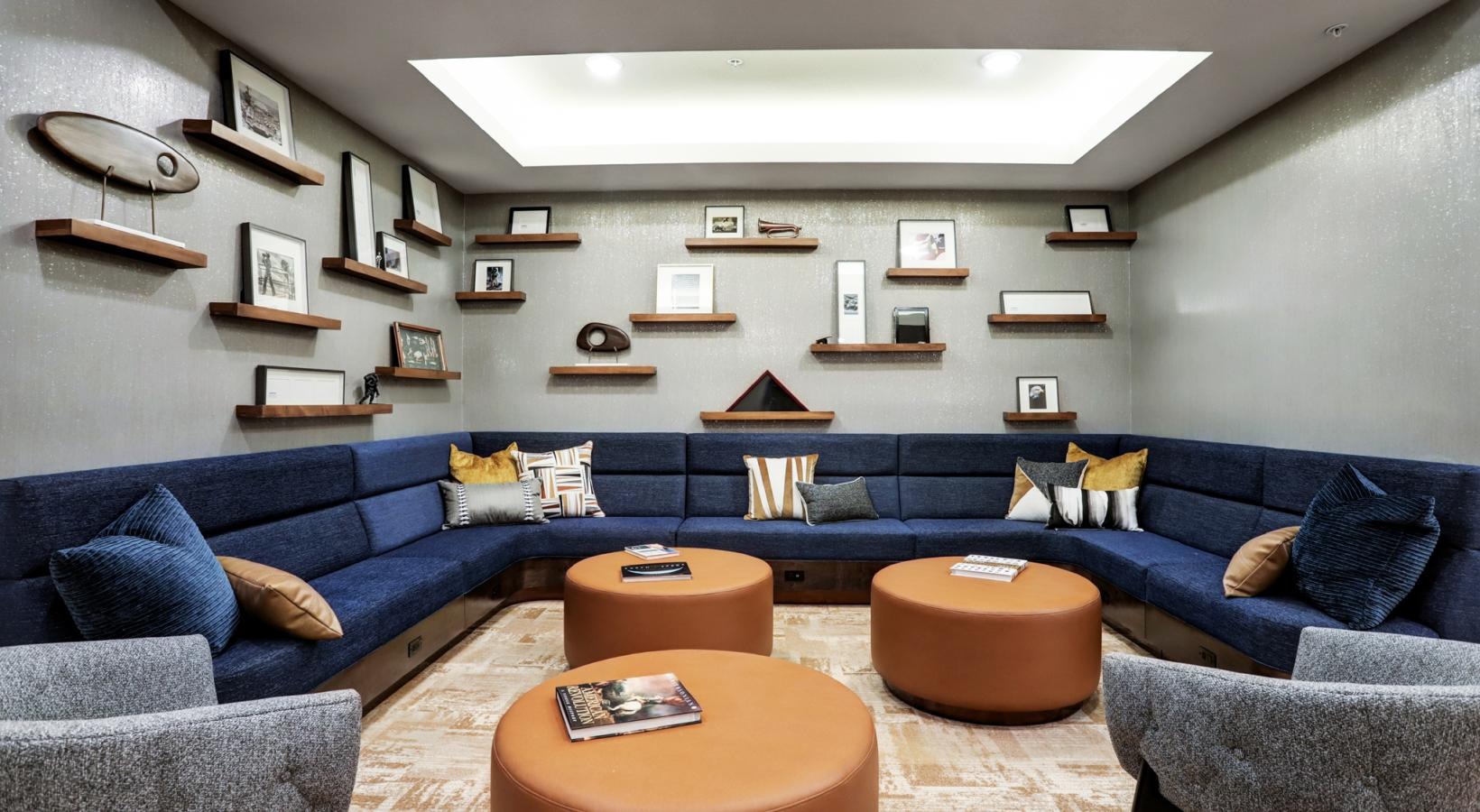 Enjoy our resident-only features a room with a blue couch and shelves with objects on them